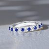 Round Cut White and Blue Sapphire Eternity Band Ring in Rhodium Plated Sterling Silver