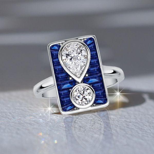Unique Pear and Round White Blue Sapphire Engagement Ring in Rhodium-Plated Sterling Silver