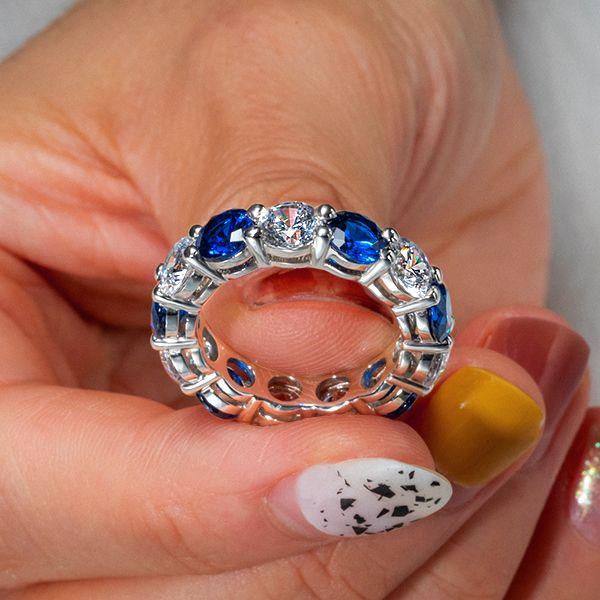 Round Cut Blue Sapphire Eternity Wedding Band in Rhodium Plated Sterling Silver
