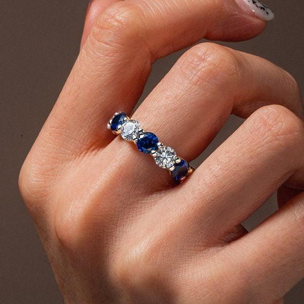 Round Cut Blue Sapphire Eternity Wedding Band in Rhodium Plated Sterling Silver